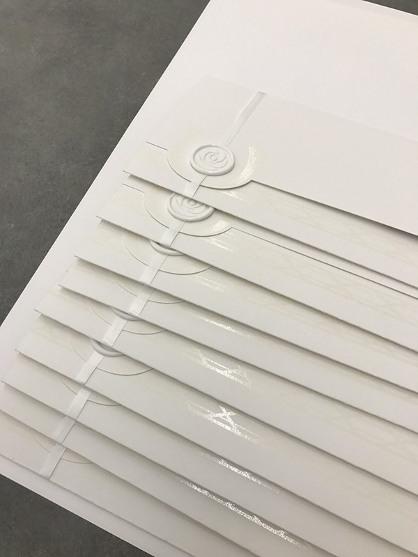 Production run - stacked envelopes with UV spot gloss rose pattern and wax seals